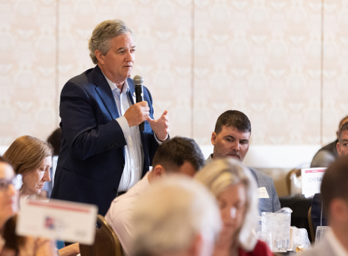 Man speaking into a microphone at an NC Chamber event
